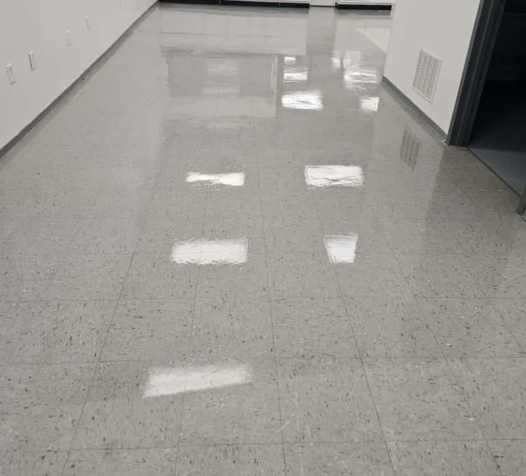 Light gray tile floor reflecting ceiling lights in an indoor facility