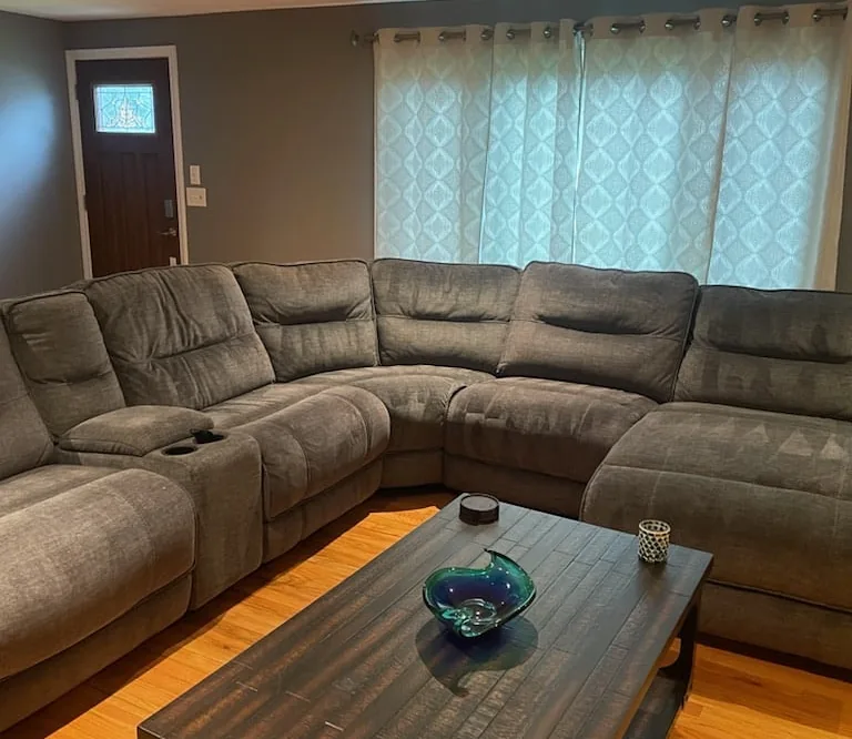 Welcoming living room with a gray L-shaped sofa, wood coffee table, and hardwood floor
