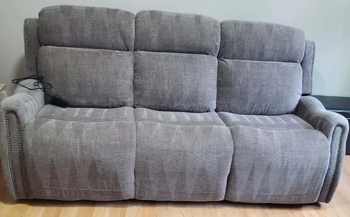 Gray fabric sofa with three cushioned seats in a home interior